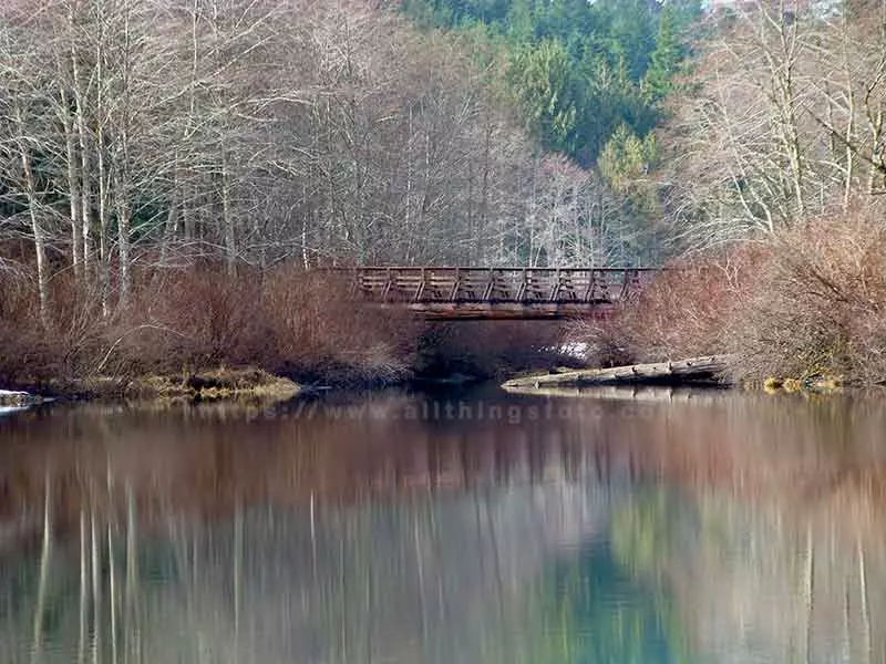 image of a pastel like reflection of bridge over Drum Lake in Strathcona Park on Vancouver Island Canada