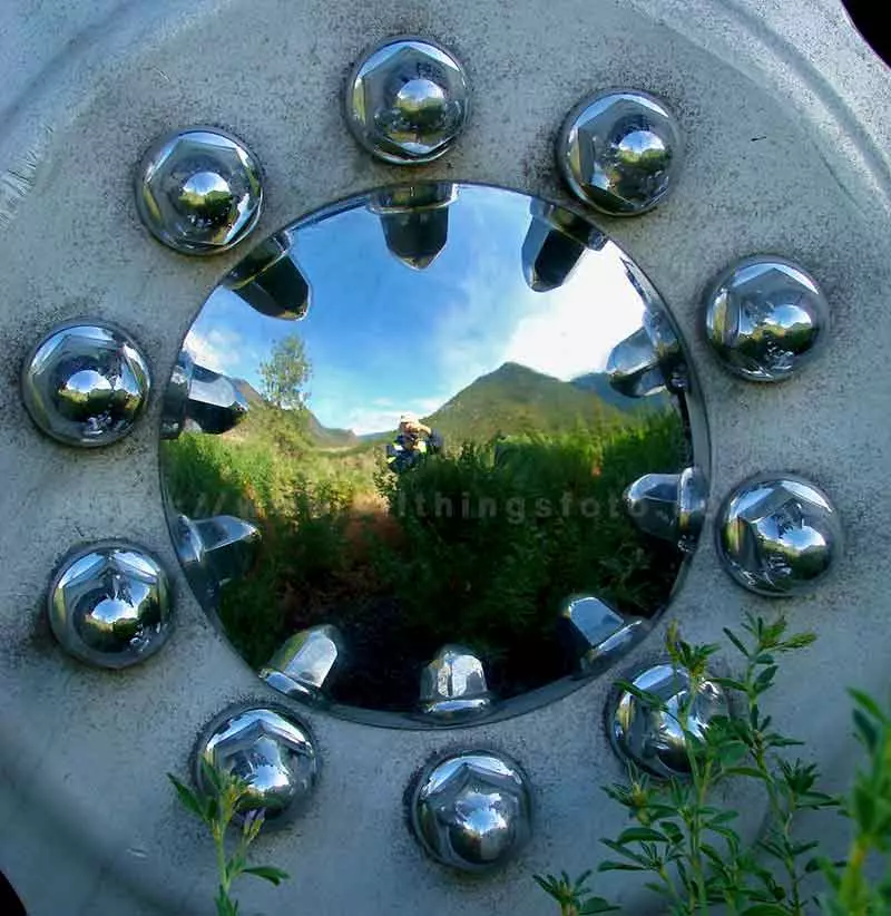 image of a mountain scene reflection and me taking the photo inside the hubcap on on my big truck